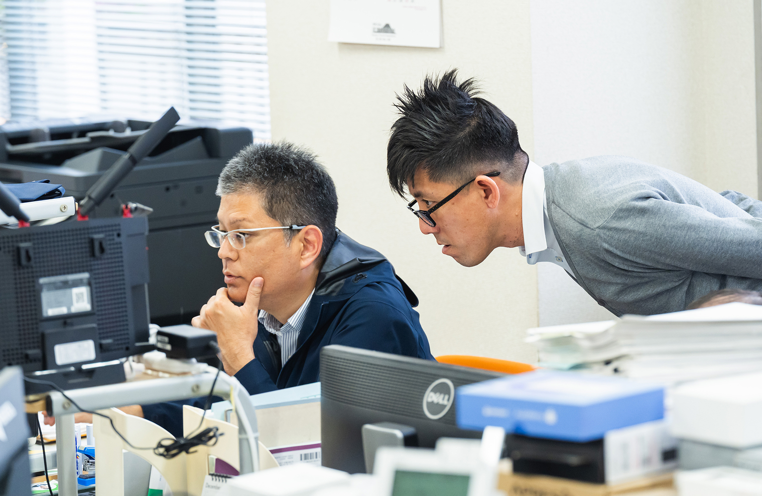 PC画面を見ながら真剣な表情をするアーク社員2名