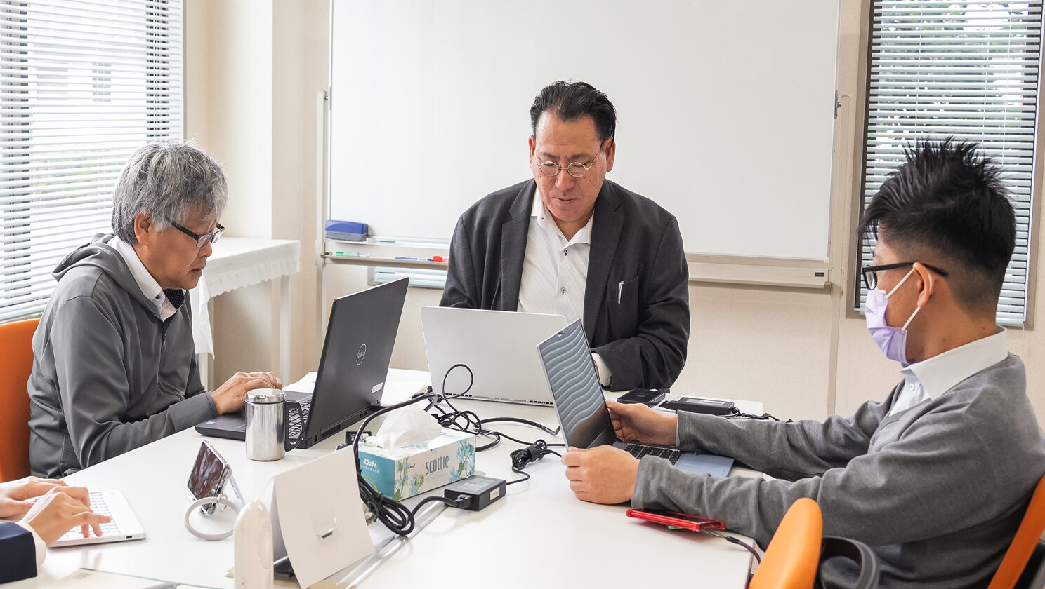 会議室でPCを開き集中するアーク社員3名